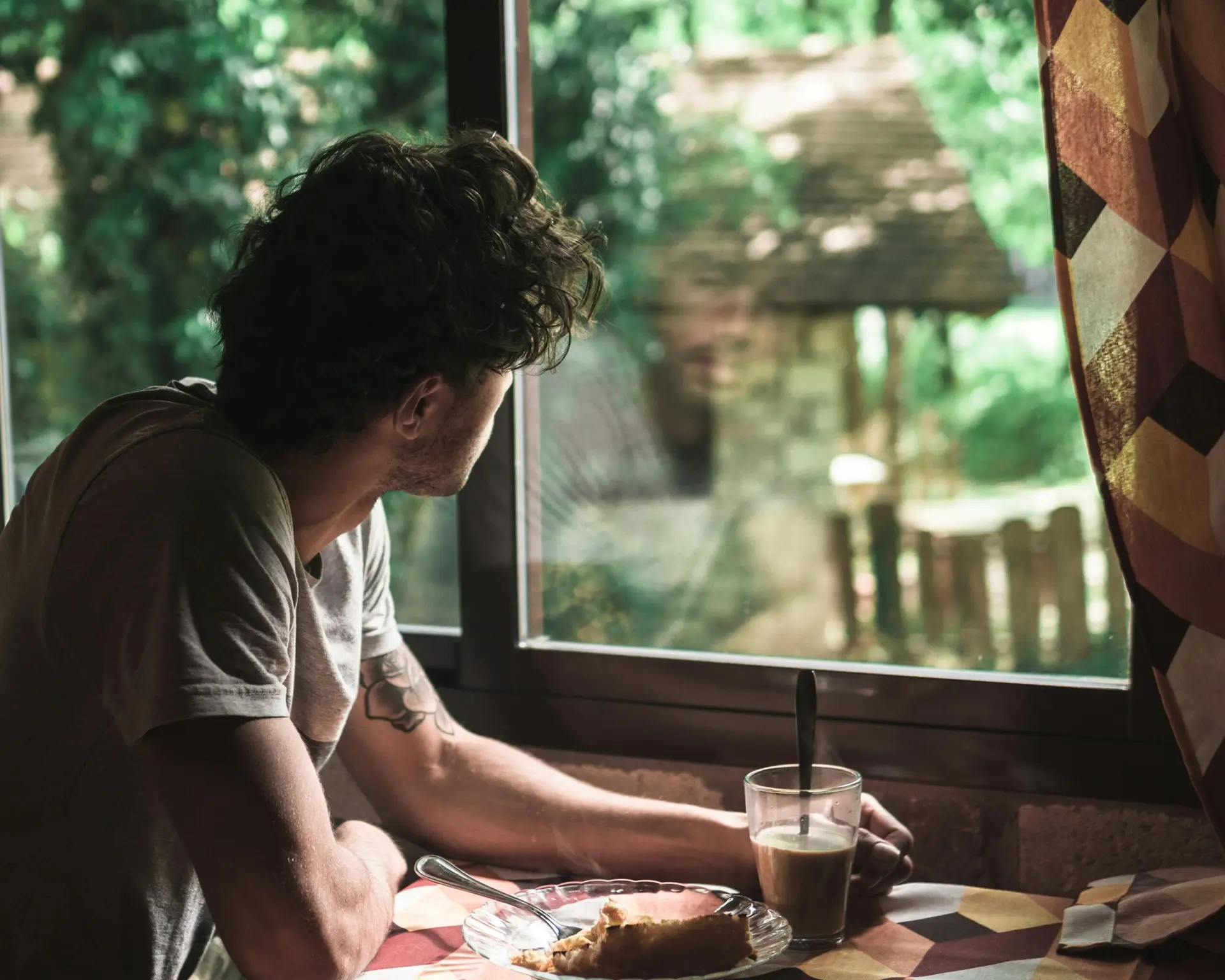 Man looking out of a window reflecting and looking at his image